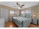 Bedroom with wood floors, light blue bedding, ceiling fan, and built in storage at 920 Morningview Dr, Tavares, FL 32778