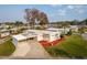Single-story home with a carport, well-manicured lawn, and mature palm trees at 920 Morningview Dr, Tavares, FL 32778