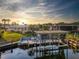 Waterfront view of property featuring a private boat dock at sunset at 920 Morningview Dr, Tavares, FL 32778