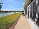 Spacious patio overlooking the backyard with a lake and beautiful landscaping at 10177 Mainsail Dr, Oxford, FL 34484