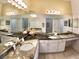Bright bathroom featuring double sinks with granite counters and ample cabinet space at 10177 Mainsail Dr, Oxford, FL 34484