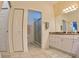 Bright bathroom featuring a glass enclosed shower, tile flooring, and white cabinets at 10177 Mainsail Dr, Oxford, FL 34484