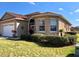 Charming home featuring a well-manicured lawn, lush landscaping, and neutral color palette at 10177 Mainsail Dr, Oxford, FL 34484