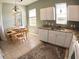 Kitchen featuring white cabinets, granite countertops, stainless appliances, and a dining table at 10177 Mainsail Dr, Oxford, FL 34484