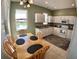 Eat-in kitchen with white cabinets, stainless steel appliances, and large window with backyard views at 10177 Mainsail Dr, Oxford, FL 34484
