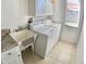 Laundry room with a utility sink, white cabinets, tile flooring, and includes a washer and dryer at 10177 Mainsail Dr, Oxford, FL 34484