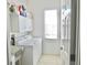 Bright laundry room equipped with washer, dryer, utility sink, storage cabinets, and a window at 10177 Mainsail Dr, Oxford, FL 34484