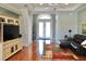 Bright living room with hardwood floors, tray ceiling, ceiling fan and large windows at 10177 Mainsail Dr, Oxford, FL 34484