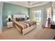 Serene main bedroom with tray ceiling, ceiling fan, and sliding glass door to sunroom at 10177 Mainsail Dr, Oxford, FL 34484