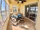 Bright sunroom with tiled floors, ceiling fan, and dining table with lake views at 10177 Mainsail Dr, Oxford, FL 34484