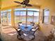 Sunroom with a ceiling fan, tile flooring, and dining set overlooking backyard lake view at 10177 Mainsail Dr, Oxford, FL 34484