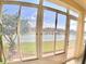 Sunroom with a view of the lake and lush greenery from the screened-in porch at 10177 Mainsail Dr, Oxford, FL 34484