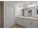 Bright bathroom with dual sinks, white cabinetry, and a large mirror at 5449 Dray Dr, The Villages, FL 32163