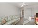 Bright bedroom featuring floral sofa, ceiling fan, and neutral carpeting at 5449 Dray Dr, The Villages, FL 32163