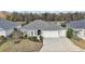 Beautiful home with lush landscaping, three-car garage, and scenic lake view at 5449 Dray Dr, The Villages, FL 32163