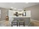 Bright kitchen featuring white cabinetry, stainless steel appliances, breakfast bar with seating, and wood-look flooring at 5449 Dray Dr, The Villages, FL 32163