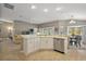 Open concept kitchen with stainless steel appliances, light wood floors, and a view of the living room and backyard at 5449 Dray Dr, The Villages, FL 32163