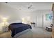 Spacious main bedroom featuring a ceiling fan, ensuite bathroom, and neutral carpeting at 5449 Dray Dr, The Villages, FL 32163