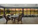 Enclosed sun room with wicker furnishings and panoramic lake views at 5449 Dray Dr, The Villages, FL 32163