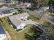 Aerial view of a charming home with a well-maintained lawn, mature trees, and a paved driveway at 1001 Del Rio Dr, The Villages, FL 32159