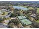 Aerial view of tennis courts, a pond, and the surrounding community offering many outdoor activities and a peaceful setting at 1001 Del Rio Dr, The Villages, FL 32159