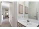 Bright bathroom featuring a white vanity, mirrored cabinet, and wood-look flooring at 1001 Del Rio Dr, The Villages, FL 32159