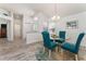 Dining area featuring a glass table, teal chairs, and wood-look floors at 1001 Del Rio Dr, The Villages, FL 32159