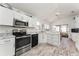 Bright eat-in kitchen with modern appliances, marble counters and wood-look flooring at 1001 Del Rio Dr, The Villages, FL 32159