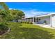 Landscaped backyard with lush green lawn, shrubbery, a screened-in lanai and exterior siding at 10338 Se 178Th St, Summerfield, FL 34491