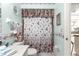 Floral-themed bathroom with a toilet, shower, and vanity near the kitchen at 10338 Se 178Th St, Summerfield, FL 34491