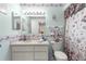 Charming bathroom with floral accents, vanity, and shower with a floral curtain at 10338 Se 178Th St, Summerfield, FL 34491