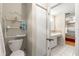 Bathroom featuring a toilet, shelving unit and partial view into an adjacent bedroom at 10338 Se 178Th St, Summerfield, FL 34491