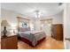 Bedroom featuring a bed, wooden dressers and hardwood floors, illuminated by a ceiling fan at 10338 Se 178Th St, Summerfield, FL 34491