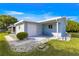 Exterior view of home showing attached garage, low-maintenance landscaping, and mature trees at 10338 Se 178Th St, Summerfield, FL 34491