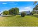 Spacious front yard showcasing a well-manicured lawn, mature trees and landscaping at 10338 Se 178Th St, Summerfield, FL 34491