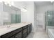 Modern bathroom featuring dual vanities, a soaking tub, and a glass-enclosed shower at 1041 Linehart Dr, Winter Garden, FL 34787