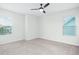 Bright bedroom featuring neutral carpet flooring, a fan, and two bright windows at 1041 Linehart Dr, Winter Garden, FL 34787