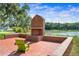 Brick fireplace in a serene outdoor seating area near the water at 1041 Linehart Dr, Winter Garden, FL 34787