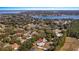 Aerial view of a beautiful home with a pool surrounded by trees and a lake in the background at 10413 Lake Hill Dr, Clermont, FL 34711