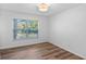 Neutral bedroom featuring wood floor, base trim, window, and natural light at 10413 Lake Hill Dr, Clermont, FL 34711