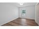 Neutral bedroom featuring wood floor, base trim, window, closet, and natural light at 10413 Lake Hill Dr, Clermont, FL 34711