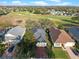 Beautiful aerial view of home on the golf course with mature trees and manicured landscaping at 1067 Mesa Verde Court, Clermont, FL 34711