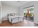 Bedroom features wood floor, queen bed, and sliding glass doors to the patio at 1067 Mesa Verde Court, Clermont, FL 34711