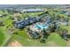 An aerial view of a beautiful clubhouse with pools, mature trees, and a manicured lawn at 1067 Mesa Verde Court, Clermont, FL 34711