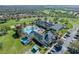 An aerial view of a beautiful clubhouse with pools, palm trees, and a parking lot at 1067 Mesa Verde Court, Clermont, FL 34711