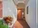 Close up of a front porch with red brick, orange door and greenery at 1067 Mesa Verde Court, Clermont, FL 34711