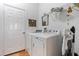 Well-lit laundry room with modern washer and dryer, shelving, mirror, and decor at 1067 Mesa Verde Court, Clermont, FL 34711