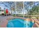 Close-up of a private outdoor spa with lush landscaping, patio, screened enclosure, and lounge area at 1067 Mesa Verde Court, Clermont, FL 34711