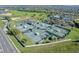 Aerial view of well maintained tennis courts with lush green surroundings and ample parking at 1067 Mesa Verde Court, Clermont, FL 34711