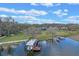 Aerial view of a waterfront property with a boat dock, lush green lawn, and mature trees at 1102 N Palmetto St, Leesburg, FL 34748